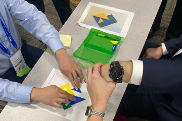 Hands assembling a tangram puzzle during a health-care simulation workshop