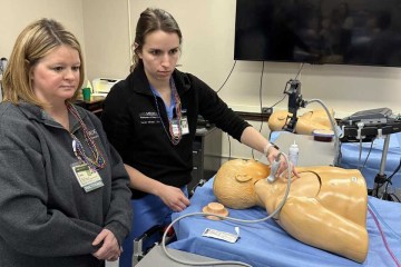 Two female advanced practice providers participate in a simulation using an ultrasound device and a manikin simulator