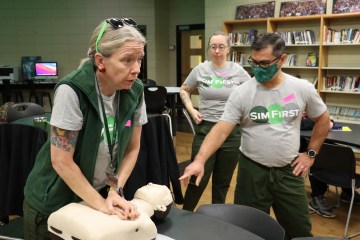 A group of health-care simulationists demonstrating CPR in a school library