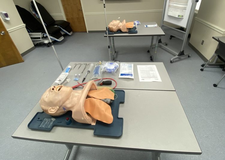 Two simulation manikin trainers sitting on tables