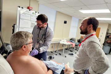 Two physicians examining a standardized patient as part of an ultrasound health-care simulation