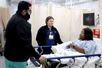 A physician and nurse participating in a health-care simulation with a standardized patient