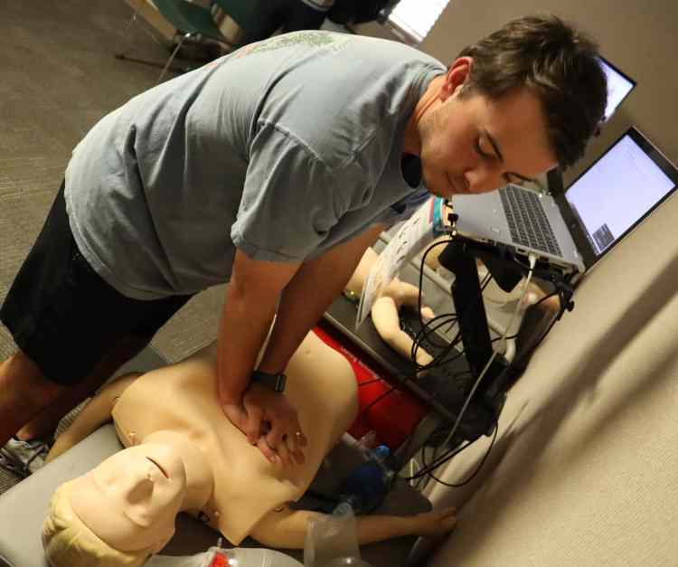 A male medical resident practicing CRP on a health-care simulation manikin