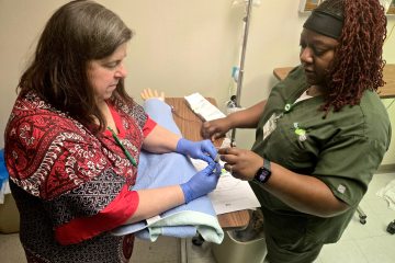 A nurse and health-care simulationist participating in an arterial line maintenance simulation