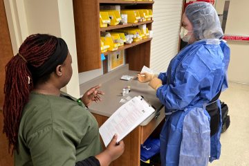 A health-care simulationist guiding a learner through a sterile compounding simulation