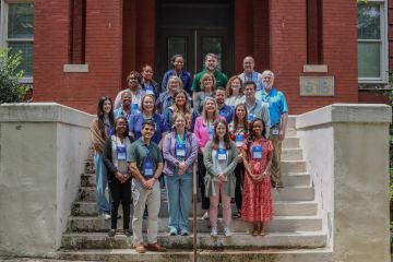 A group of medical professionals standing in front of a old brick building