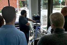 A group of healthcare professionals studying a lung simulator as part of a pilot simulation