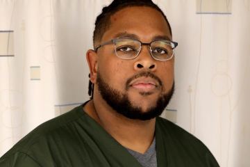 A man in olive green medical scrubs