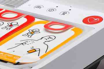 A close-up of a white, yellow and red AED device