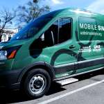 A green Ford Transit van marked as the UAB Mobile Simulation Lab