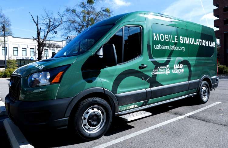 A green Ford Transit van marked as the UAB Mobile Simulation Lab