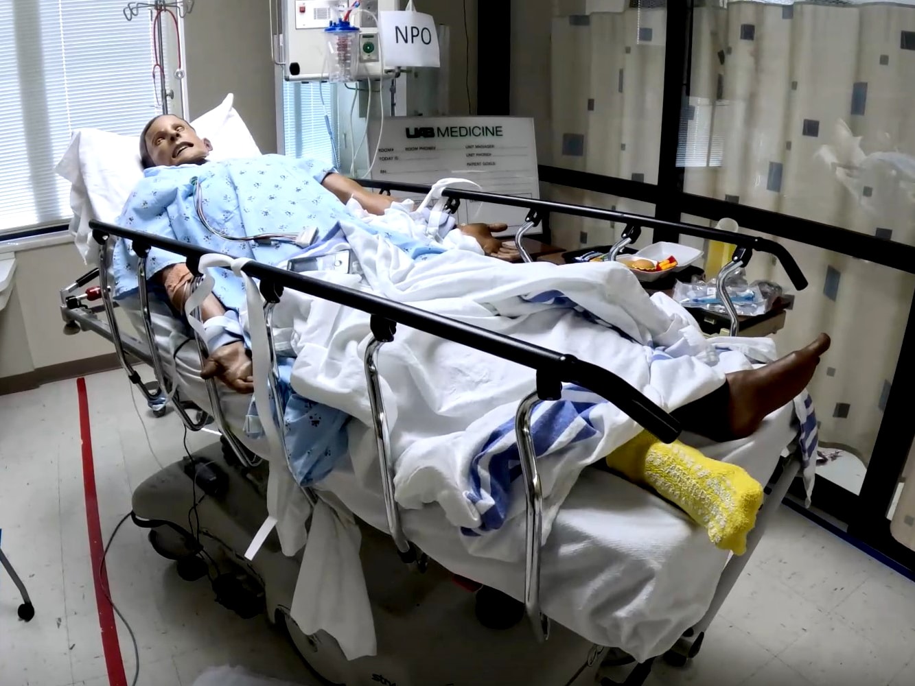 A health-care simulation manikin laying in a hospital bed