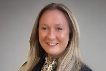 A woman with blond hair wearing a black blazer