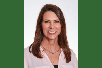 A headshot of a Caucasian woman with brown hair wearing a white blouse