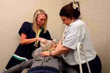 Two learners practice emergency response skills on a healthcare simulation manikin, with one using a resuscitation bag while the other performs chest compressions.